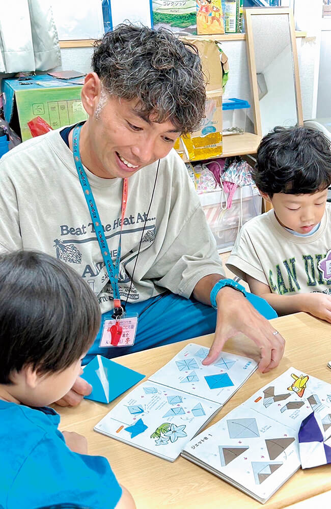 「子どもとおりがみをしているおとうさん」